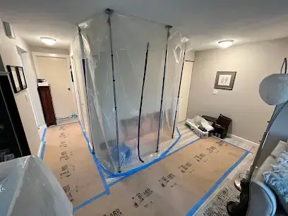 Room sealed with zippered plastic containment while air movers dry the floor
