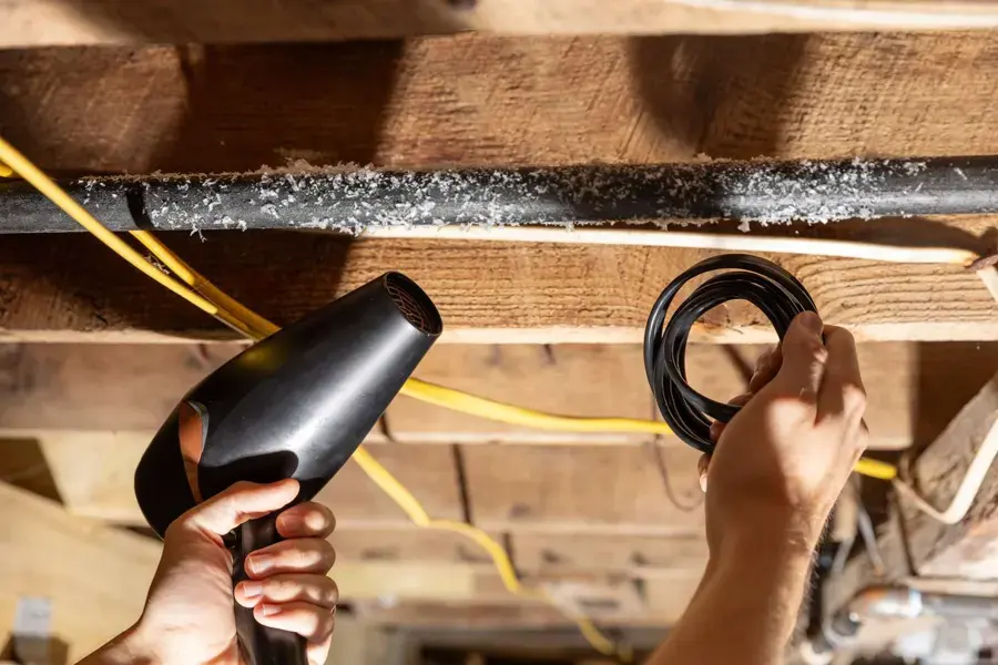 Frozen pipe being thawed with warm air between floor joists in Sammamish, WA