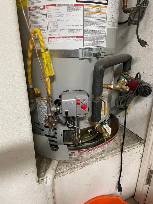 Gas water heater with a bucket at its base catching a leak in Sammamish, WA